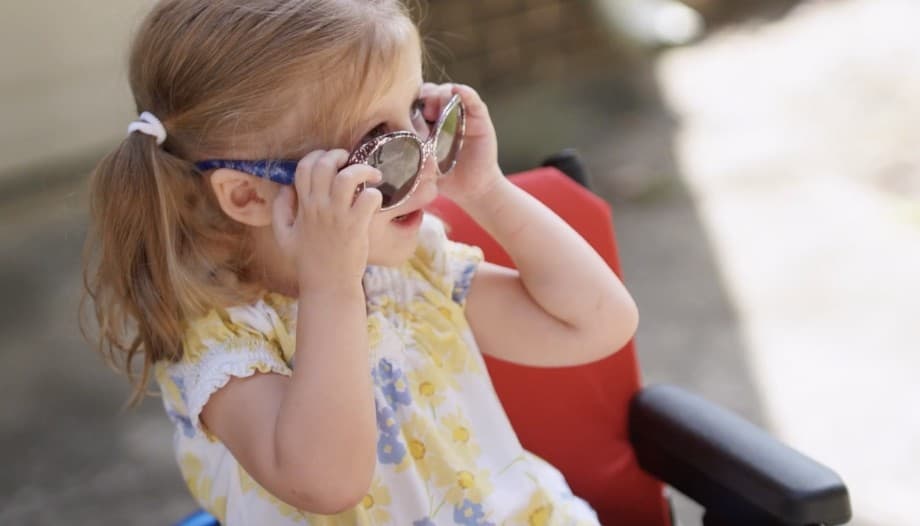 Video: a young girl tries on big girl sunglasses