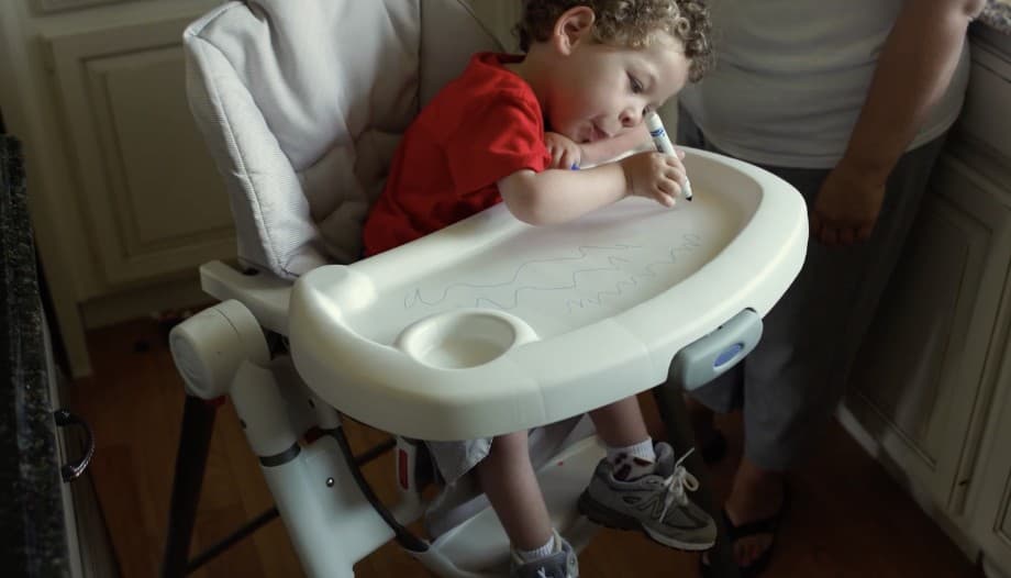 Video: a young child draws on the tray of a highchair