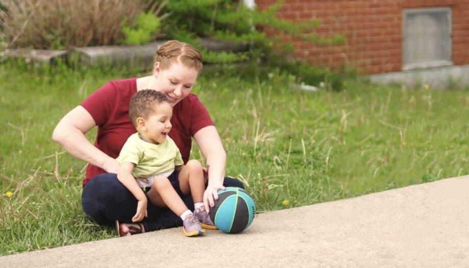 Video: a small boy and his mother play with a ball