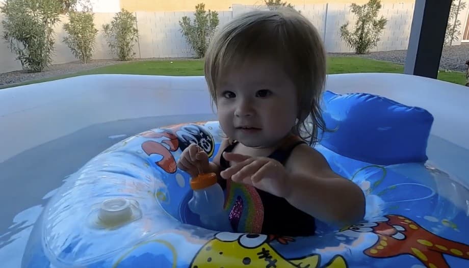Video: a young girl plays in an inner tube